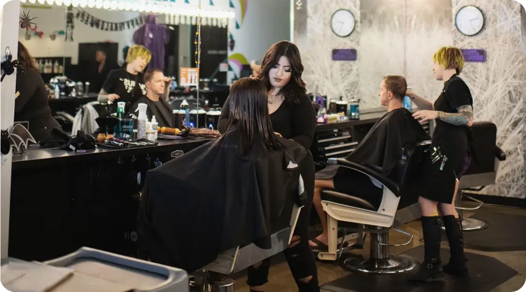 Hair stylist cutting a client’s hair inside Birds Barbershop